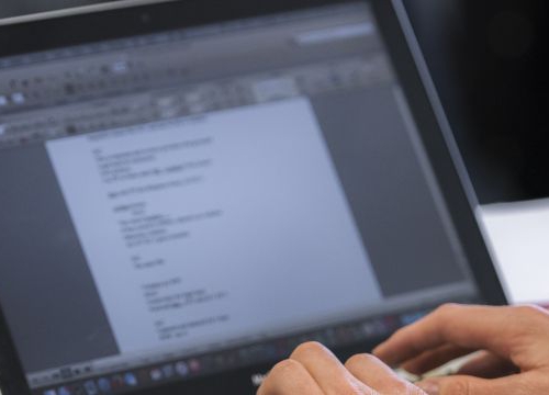 Student during a class taking notes on her labtop