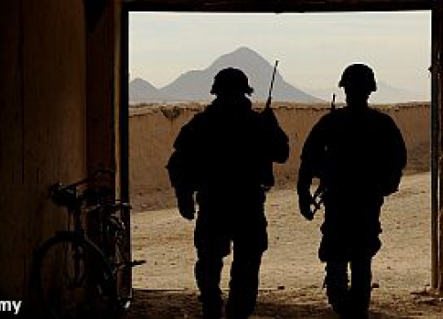 Two US soldiers walking out of a building