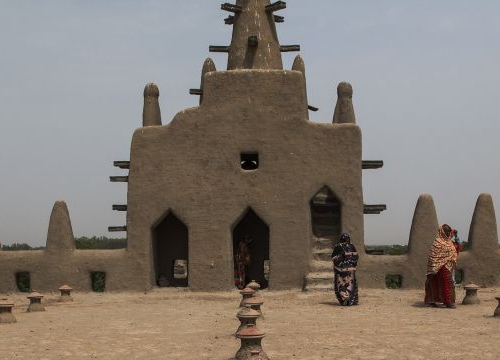 Women walk on the roof of the Great Mosque of Djenné after praying. The Great Mosque of Djenné was designated a World Heritage Site by the United Nations Educational, Scientific and Cultural Organization (UNESCO) in 1988 along with the old town of Djenné,