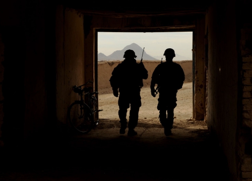 Two U.S. Soldiers walk out of a building