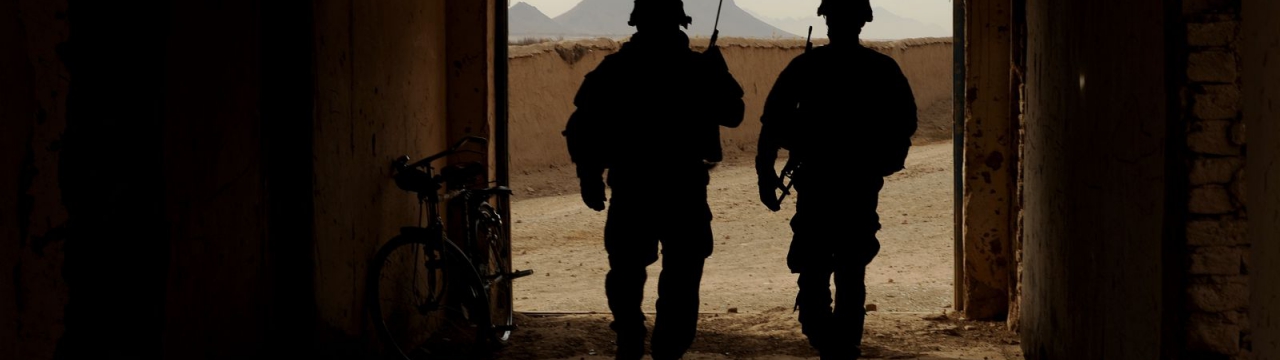 Two U.S. Soldiers walk out of a building