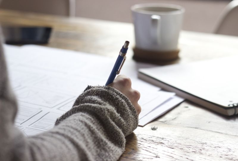 Person writing at his/her desk