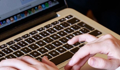 A participant to a Geneva Academy event takes note on a computer