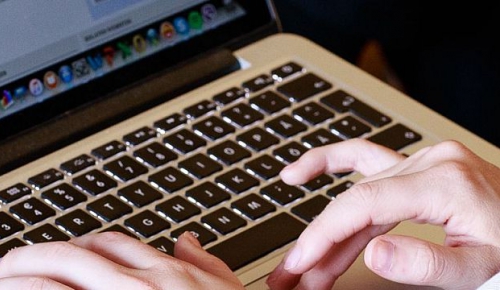A participant to a Geneva Academy event takes note on a computer
